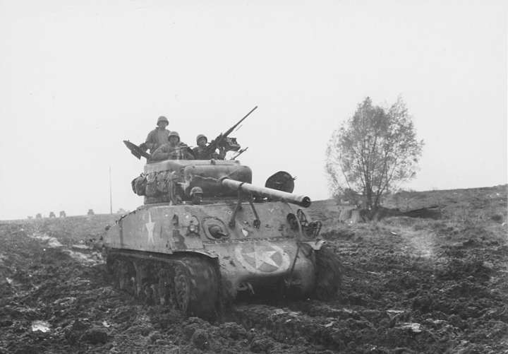 This M4 medium tank is put thru the mud by members of the Motor transport unit, near Nancy, France. 5. November 1944